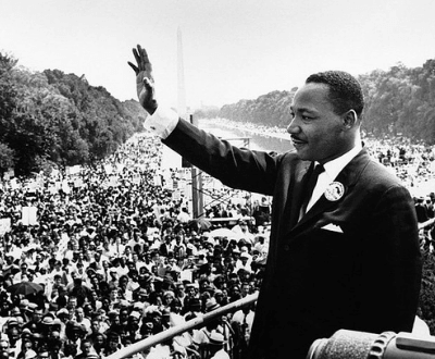 Dr. Martin Luther King, Jr. waving at a crowd after his speech.