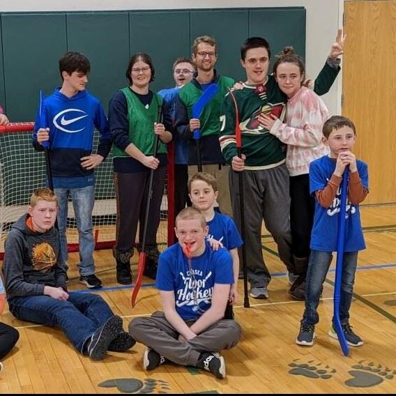 Group of kids pose for photo inside gym. Kids wearing washable pennies.