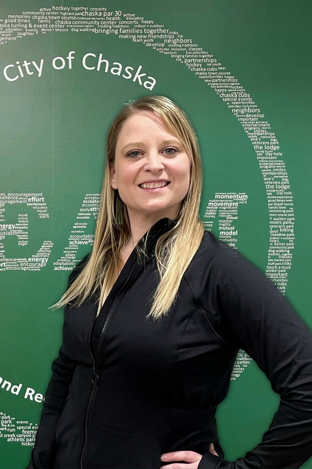 Personal Trainer Sarah Boomgaarden in black shirt standing in front of green TEAM sign